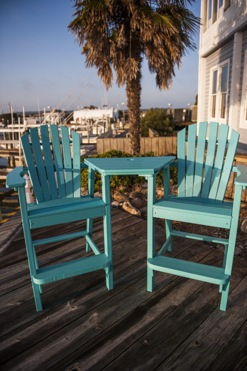 poly plastic bar chair set with a connecting tete-e-tete table on dock with palm tree